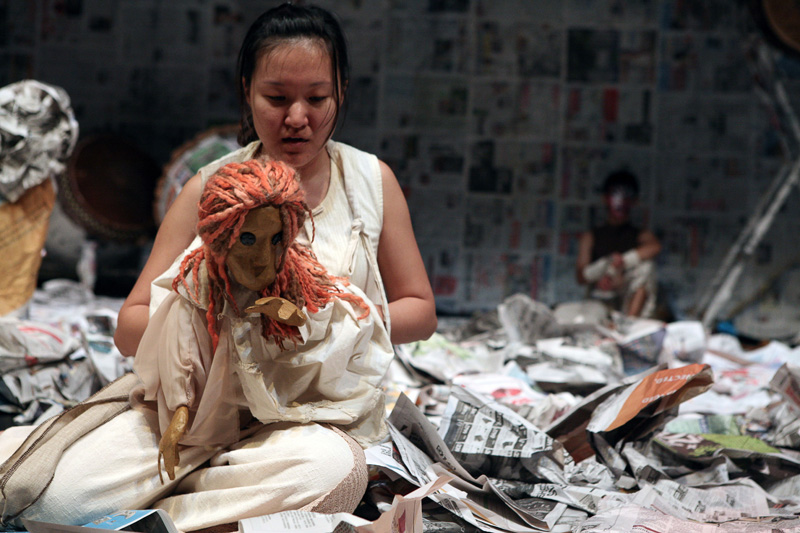 An actress holding a female puppet in Death of A Hero by Paper Monkey Theatre Singapore