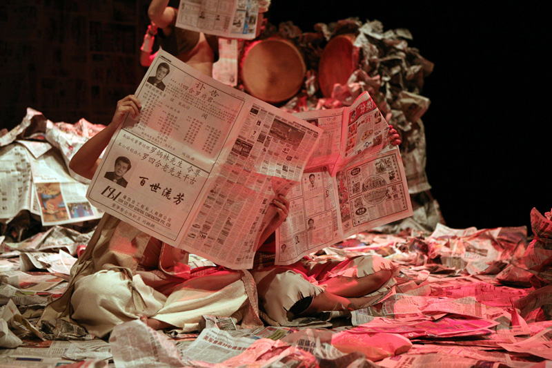 People holding newspaper obituary in Death of A Hero by Paper Monkey Theatre Singapore