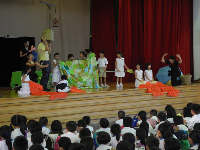 Actors interacting with student audience on stage in Dragon Dance Community Tour by Paper Monkey