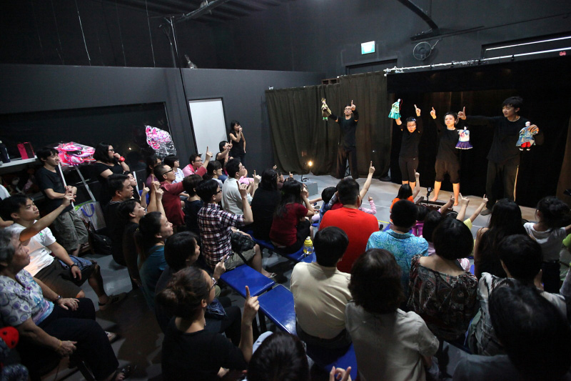 Four actors holding hand puppets with back view of audience At Treehouse The Three Big Bullies by Paper Monkey Theatre