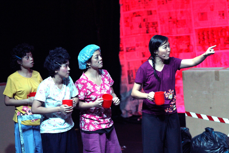Four ladies holding a red mug with one pointing her finger in Paper Monkey Mercury