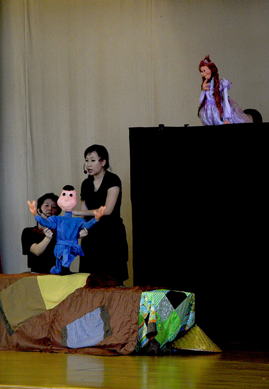 Princess Puppet looking down at boy puppet in Dragon Dance Community Tour by Paper Monkey