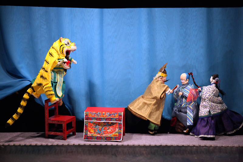 Traditional Chinese hand puppet of tiger, two men and a lady At Treehouse The Three Big Bullies by Paper Monkey Theatre