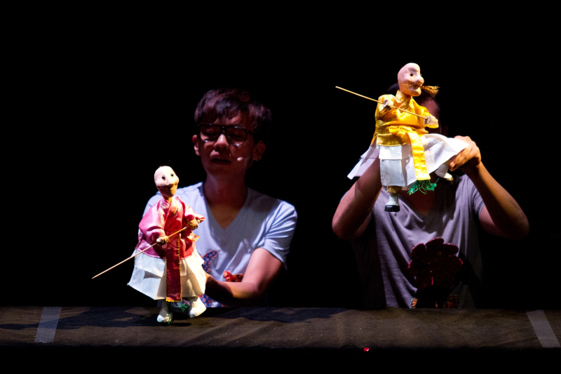 Two hand puppets with sticks fighting in The Three Big Bullies by Paper Monkey Theatre Singapore
