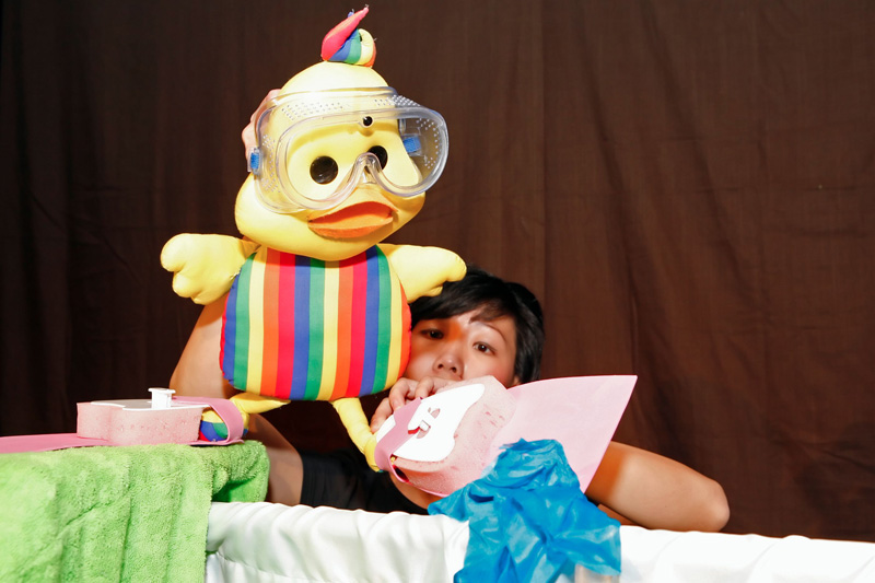 Duckie in goggles and flippers learning to swim in Duckie Can't Swim by Paper Monkey Theatre