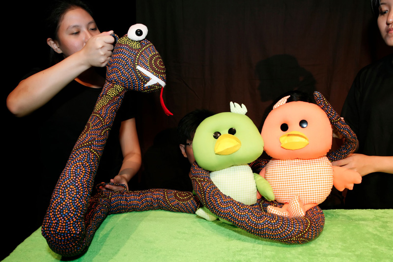The snake coiling the two duckies in Duckie Can't Swim by Paper Monkey Theatre