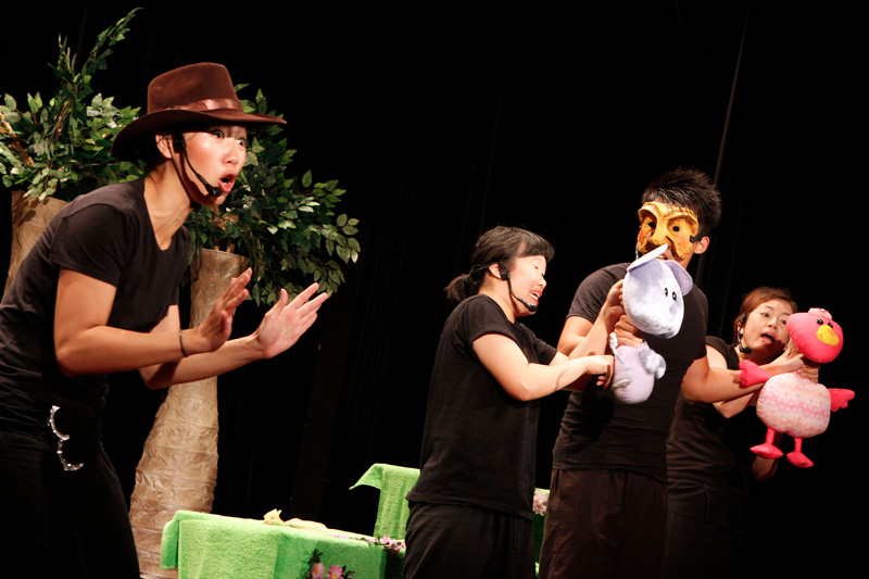 An actress with cowboy hat and two animal puppets in Tree Neighbours by Paper Monkey Theatre Singapore