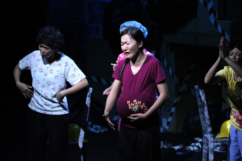 Pregnant lady holding her tummy and three housewives behind her in Paper Monkey Mercury