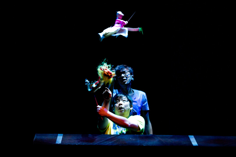 A dragon puppet with a boy puppet flying over it in The Three Big Bullies by Paper Monkey Theatre Singapore