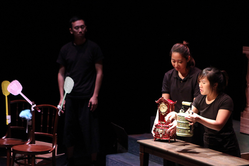 A old red clock, a tingkat and old chairs in The Nonya Nightingale by Paper Monkey Theatre Singapore
