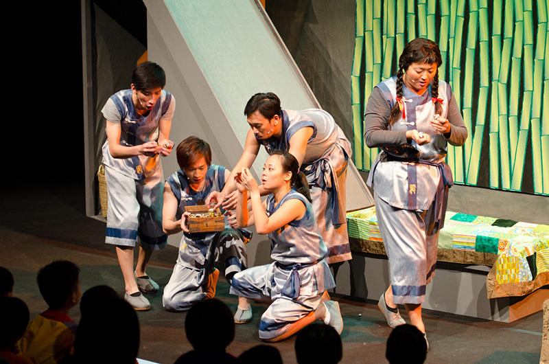 Actors looking at balls on their hands in Dragon Dance by Paper Monkey Theatre Singapore