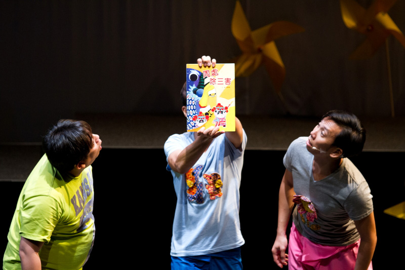 An actor holding the programme book of The Three Big Bullies by Paper Monkey Theatre Singapore