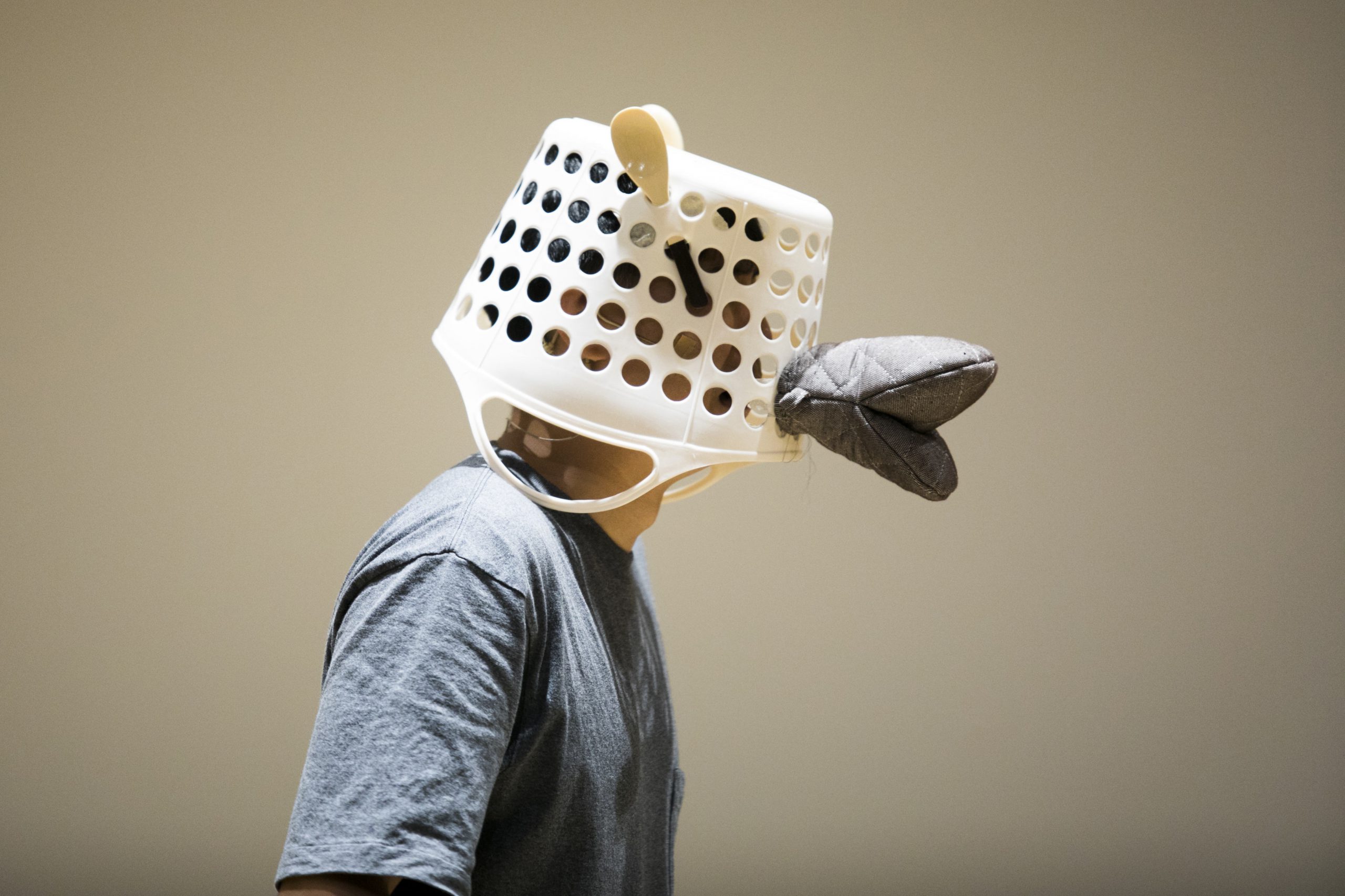 An actor wearing a basket head gear with a hand glove as lips in School Show The Wolf of Mr Dong Guo by Paper Monkey Theatre Ltd