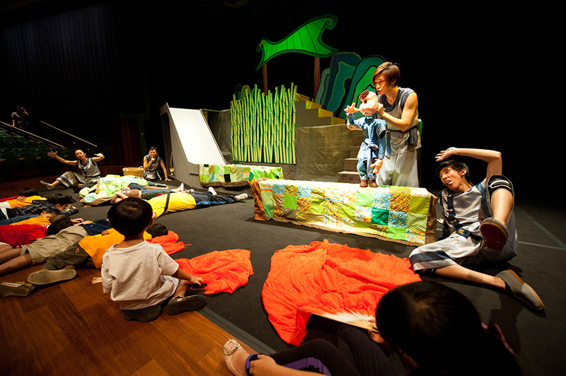 Boy puppet interacting with children audience on stage Dragon Dance by Paper Monkey Theatre Singapore