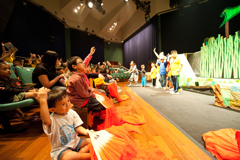 Children audience happily raising their hands Dragon Dance by Paper Monkey Theatre Singapore