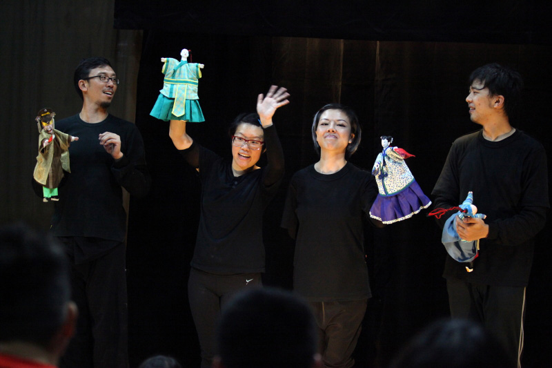 Four actors holding traditional chinese hand puppets with one actress waving at audience At Treehouse The Three Big Bullies by Paper Monkey Theatre