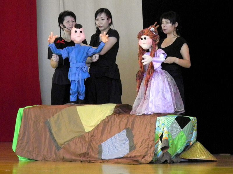 Princess life size puppet with boy puppet manipulated by actors in Dragon Dance Community Tour by Paper Monkey